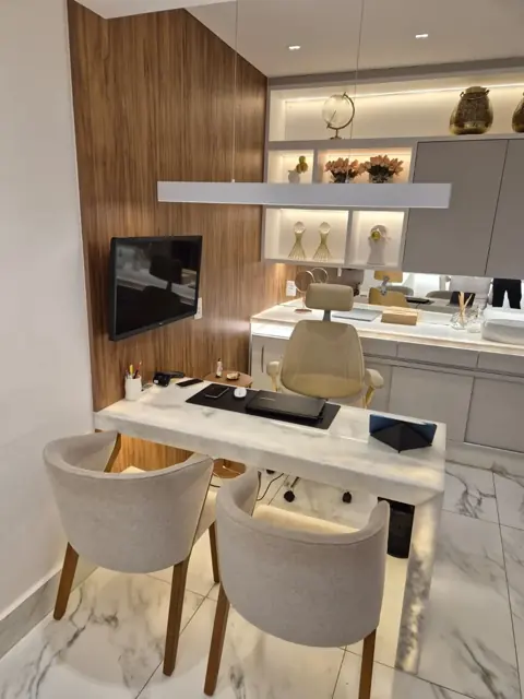 Consultório com mesa de mármore e cadeiras claras